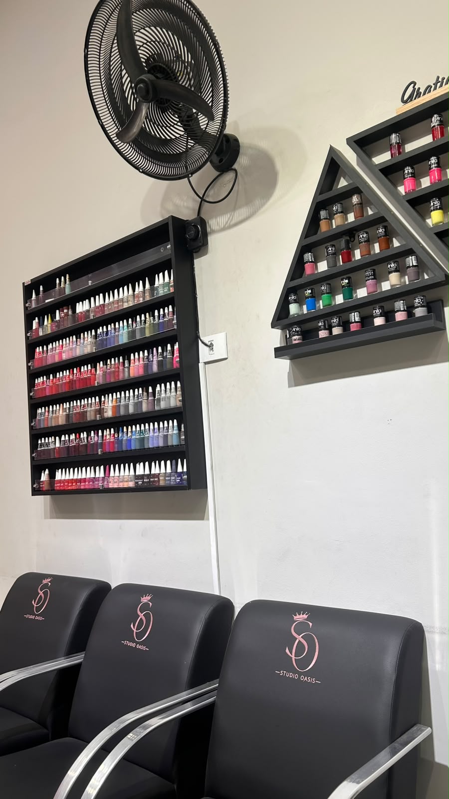 Espaço de manicure do Studio Oasis com esmaltes e poltronas